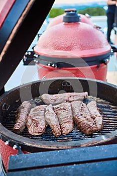 Thick strip steak being grilled outdoors. Shallow dof