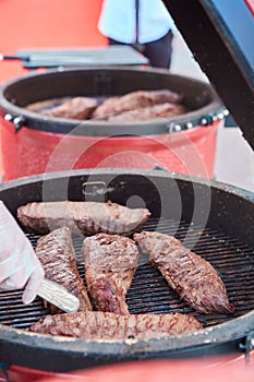 Thick strip steak being grilled outdoors. Shallow dof