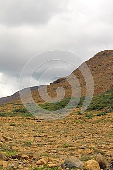 Thick summer clouds loom over an expanse of the stark rocky beauty of the Tablelands ophiolite Gros Morne National Park Canada