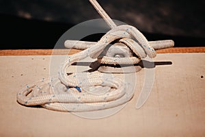 Thick white rope wrapped around metalbolt on concrete floor