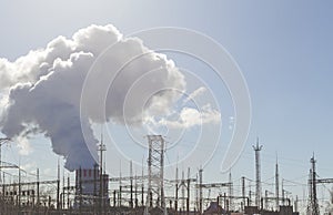 Thick white smoke from the chimney of a nuclear power plant. High-voltage