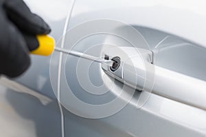 Thief breaking into car with screwdriver