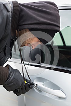 Thief breaking into car with screwdriver