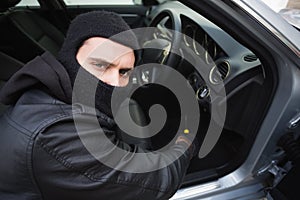 Thief breaking into car with screwdriver