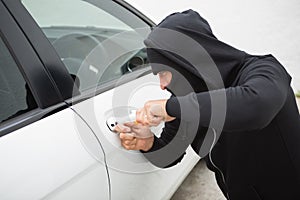 Thief breaking into car with screwdriver