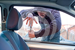 Thief breaking the car window to steal one car photo