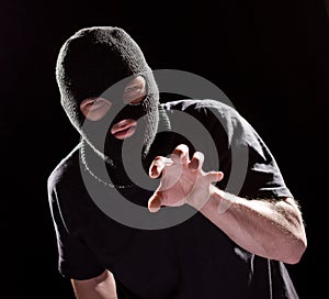 Thief Burglar in Mask Grabbing by Hand. Crime Man in Black