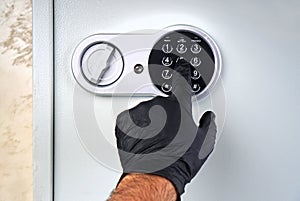 Thief. Hand in black glove opens safe. Theft concept