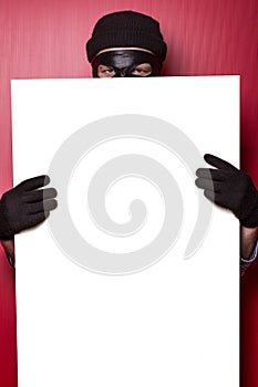 Thief hiding behind advert photo