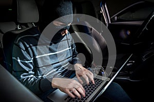 Thief with a laptop inside a car