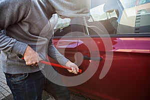 Thief Opening Car's Door With Crowbar