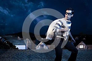 Ladrón sobre el techo de casa por la noche 