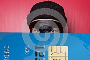 Thief smiling with big blue credit card