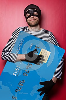 Thief smiling with big blue credit card