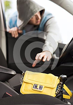 Thief stealing bag from the car