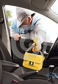 Thief stealing bag from the car