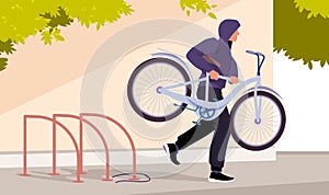 Thief stealing bicycle from rack in public city area, bike theft on street by man