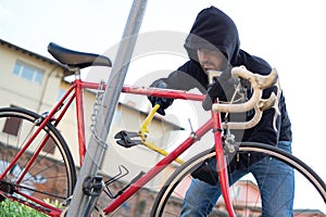 Thief stealing a bike in the city street