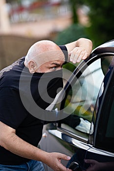 Thief stealing a car, robber. Car thief steal car breaking door. Criminal job burglar hijacks auto thief. Street crime