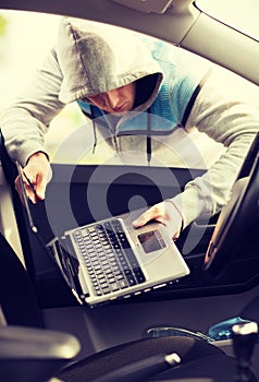 Thief stealing laptop from the car