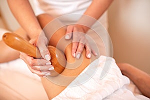 Thigh massage with a hand held massage tool