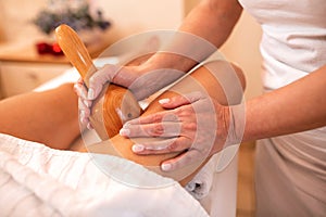 Thigh massage with a hand held massage tool