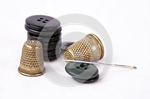 Thimble with a needle and black buttons