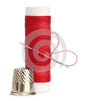 Thimble and needle with red sewing thread isolated on white