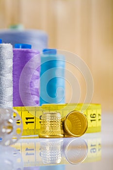 Thimbles and tapeline, spools on table