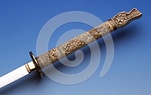 Thin blade knife with a very worked handle ending in a dragon`s head