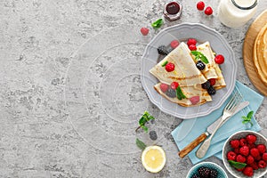 Thin crepes with fresh berries and lemon zest. Pancakes with raspberry and blackberry