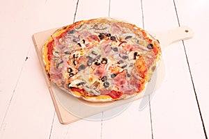 Thin crust pizza with red onion, ham, mushrooms, slices of black olives, mozzarella cheese with tomato