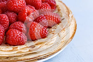 Thin delicious pancakes decorated with fresh raspberries. Macro food photography
