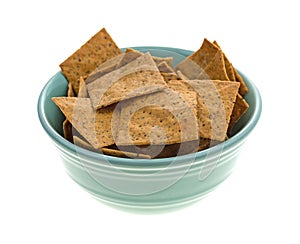 Thin gourmet snack crackers in a green bowl