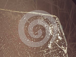 Thin icy board against strong sun light. In floe are visible cracks