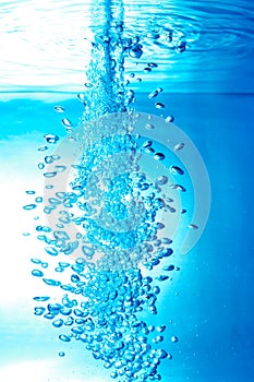 a thin jet of water penetrates the water surface photo