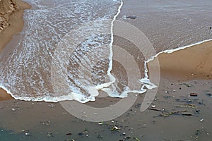 THIN LAYER OF SEAWATER RETRACTING FROM BEACH