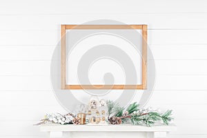 Thin light wood frame on mantelpiece with spruce branches