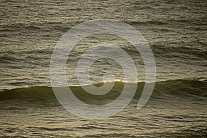 THIN LINE OF LIGHT ON CREST OF WAVE