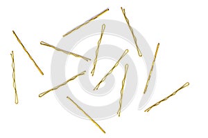 thin metal hair clips in gold color in large quantities on a white isolated background