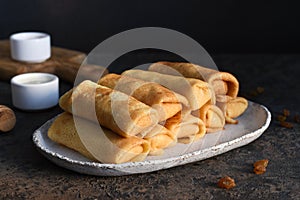 Thin pancakes with cottage cheese on a dark concrete background. Platbands. National, traditional dish of Belarus and Ukraine