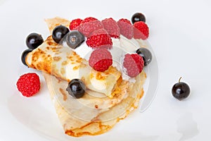 Thin pancakes with currant and berry sauce