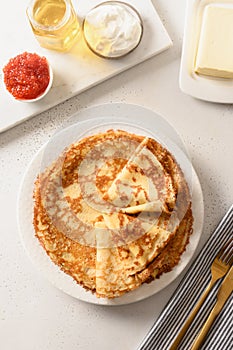 Thin pancakes with different tops, honey, sour cream, red caviar. Russian traditional breakfast.