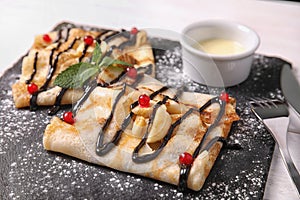 Thin pancakes served with sauce and berries