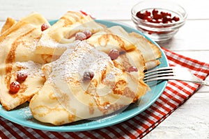 Thin pancakes served with sugar powder and berries