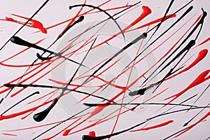 Thin red and black lines and splashes drawn on white background. Abstract art backdrop with brush decorative stroke