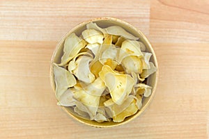 Thin slice dried Brown Lily Bulb, also called Bai He used in traditional Chinese medicine in wooden bowl