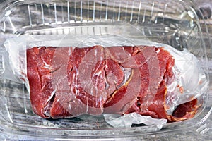 Thin slices of beef pastrami, made from beef brisket, raw meat is brined, partially dried, seasoned with herbs and spices, then