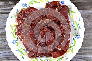 Thin slices of beef pastrami, made from beef brisket, raw meat is brined, partially dried, seasoned with herbs and spices, then