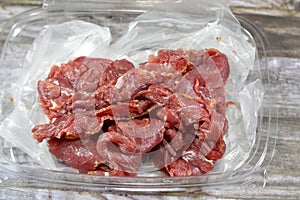 Thin slices of beef pastrami, made from beef brisket, raw meat is brined, partially dried, seasoned with herbs and spices, then